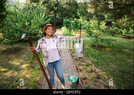 Porträt einer glücklichen erfolgreichen Bäuerin, die im Frühjahr gerne in der Öko-Farm gärtet. Gartenbau , Landwirtschaft Stockfoto