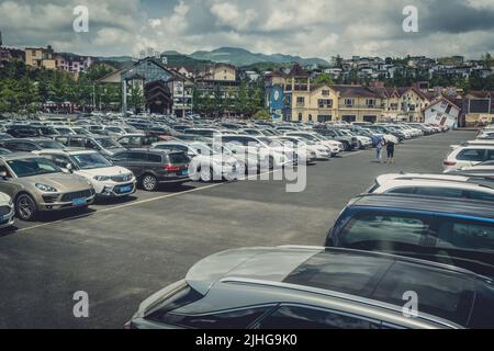 Wulong, China - August 2019 : Privatwagen auf einem großen Parkplatz am Eingang des Museums im Wulong Nationalpark Stockfoto