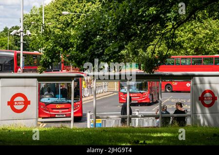 London, UK - June 2020 : Menschen pendeln auf die Busse warten, die im Sommer vom Busbahnhof Crystal Palace auf einer belebten London Street abfahren Stockfoto