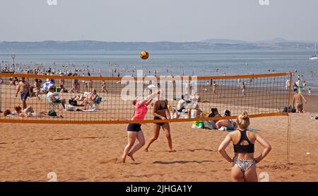 Portobello Seaside, Edinburgh, Schottland, Großbritannien. 18.. Juli 2022. Thermometer, die in Edinburgh eine Temperatur von 30 Grad Celsius anzeigen, aber diese jungen Damen, die am belebten Sandstrand immer noch Volleyball spielen, nicht verhindern. Kredit: Newsandmore/alamy Live Nachrichten. Stockfoto