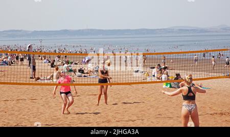 Portobello Seaside, Edinburgh, Schottland, Großbritannien. 18.. Juli 2022. Thermometer, die in Edinburgh eine Temperatur von 30 Grad Celsius anzeigen, aber diese jungen Damen, die am belebten Sandstrand immer noch Volleyball spielen, nicht verhindern. Kredit: Newsandmore/alamy Live Nachrichten. Stockfoto