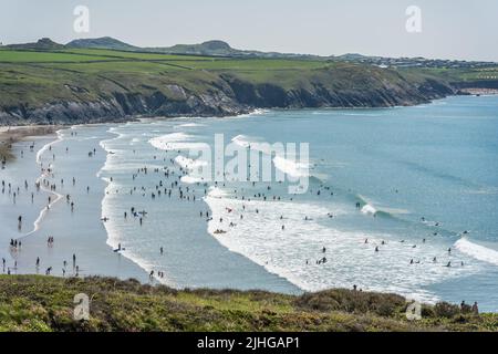 Tenby, Wales - Mai 2021 : Massen von Menschen schwimmen, sonnen und genießen heißen Sommertag am Whitesands Bay Strand und Klippen Stockfoto