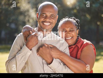 Portrait glücklich liebevolles reifes afroamerikanisches Paar, das während des Sommers einen intimen Moment draußen im Park teilt. Verliebte ältere Erwachsene lächeln Stockfoto