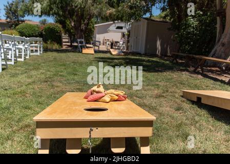 Hinterhof-Veranstaltungsort eingerichtet, um eine anspruchsvolle und wettbewerbsfähige Spiel von Maisloch mit den Bohnensäcken unterzubringen. Stockfoto