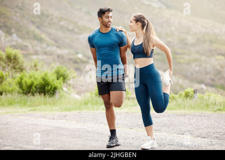 Fit jungen Mann und Frau Stretching Beine für Aufwärmen, um Verletzungen zu vermeiden, während gemeinsam trainieren im Freien. Interracial paar und motivierte Athleten Stockfoto