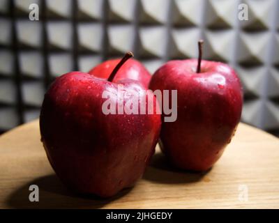 Drei große rote Äpfel der Sorte Red Chief. Wassertropfen auf Früchten. Stockfoto