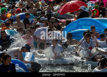 Ulm, Deutschland. 18.. Juli 2022. An der Nabada tummeln sich zahlreiche Menschen auf der Donau. Die Nabada ist eine Art Karnevalszug auf dem Wasser, an dem mehrere Tausend Menschen teilnehmen und das Highlight des Ulmer Stadturlaubs Schwörmontag. Quelle: Stefan Puchner/dpa/Alamy Live News Stockfoto