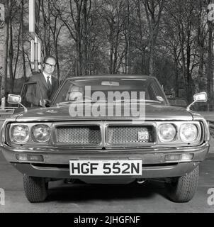 1974, historisch, ein neuer Käufer des neuen Datsun 240k GT sitzt in seinem Auto, der Verkäufer steht dabei, das Auto wird bis April 1975 besteuert. Datsun war der Markenname, der von Nissan im Ausland verwendet wurde, und die Datsun K Series war ein neu aufzeicheter Nissan Skyline C110. Der Name Skyline geht auf das Jahr 1957 und die Prince Motor Company zurück, die Nissan 1967 erwarb. Stockfoto