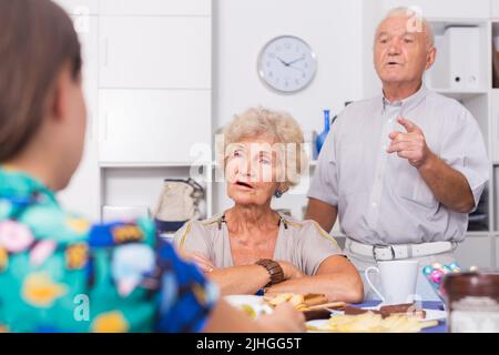 Ernsthafte ältere Eltern, die unangenehme Gespräche mit ihrer Tochter führen Stockfoto