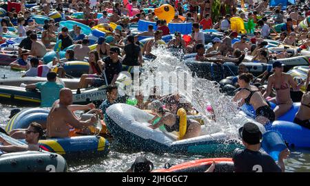 Ulm, Deutschland. 18.. Juli 2022. Während der Nabada nehmen zahlreiche Menschen an einer Wasserschlacht auf der Donau Teil. Die Nabada ist eine Art Karnevalszug auf dem Wasser, an dem mehrere Tausend Menschen teilnehmen und das Highlight des Ulmer Stadturlaubs Schwörmontag. Quelle: Stefan Puchner/dpa/Alamy Live News Stockfoto