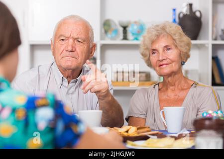 Ernsthafte ältere Eltern, die unangenehme Gespräche mit ihrer Tochter führen Stockfoto