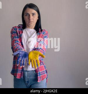 Porträt einer schönen ukrainischen Frau mit bemalten Händen. Blau und gelb als Symbol der Ukraine. Speicherplatz Kopieren Stockfoto