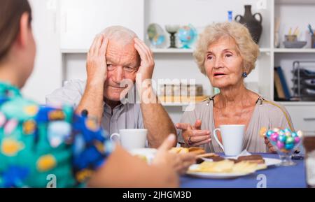 Ernsthafte ältere Eltern, die unangenehme Gespräche mit ihrer Tochter führen Stockfoto