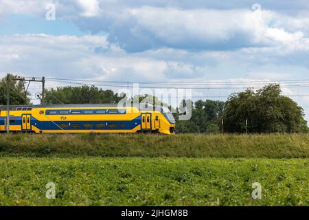 Blick auf einen Intercity-Zug, der durch die malerische Landschaft der Niederlande fährt Stockfoto