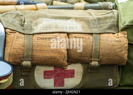 Nahaufnahme von zwei British Medical Taschen aus dem Weltkrieg mit Muschelkleidern unter den Haupträdern über dem roten Kreuz-Emblem. Stockfoto