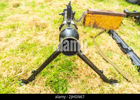 Blick auf das Fass eines deutschen Maschinengewehrs aus dem zweiten Weltkrieg, M34. Pistole auf Gras mit Schussfutter. Enger Fokus. Stockfoto