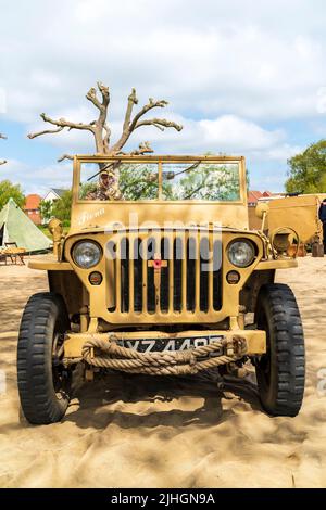 Low-Angle-Ansicht der Vorderseite eines Vintage-Jeeps aus dem zweiten Weltkrieg, der in den Farben der britischen Desert Rats der Armee von 8. gelb gestrichen wurde. Ereignis der 40er Jahre, Stockfoto