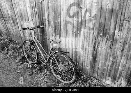 Ein verlassene Fahrrad verließ einen Fußpfad aufrecht und wurde jeden Tag schmutzig. Stockfoto