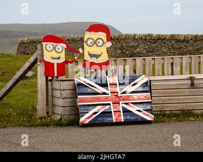 Bunte Figuren und ein Union Jack vor einem Haus in East Burra, Shetland, Schottland, Großbritannien. Stockfoto