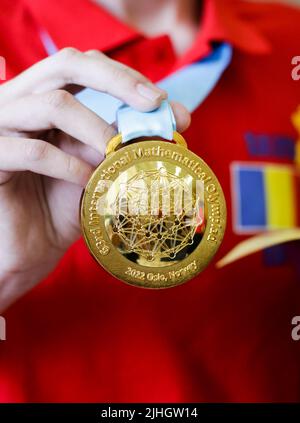 Otopeni, Rumänien - 17. Juli 2022: Details mit einer Goldmedaille, die ein rumänischer Teilnehmer bei der Internationalen Mathematischen Olympiade 63. gewonnen hat. Stockfoto