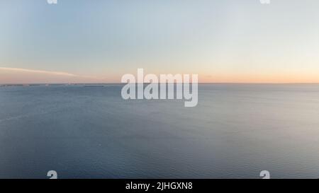 Horizont über Meer karge, minimalistische Meereslandschaft. Ruhiges blaues Meer und klarer Himmel bei Sonnenuntergang große Panorama-Luftaufnahme Stockfoto