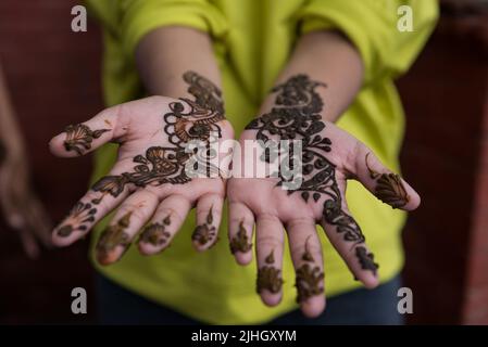 Kathmandu, Nepal. 18.. Juli 2022. Eine Anhängein zeigt ihre Hände, die am ersten Tag des Sharwan Brata Festivals mit Mehendi (Henna) geschmückt sind. Während des Monats Shrawan beten nepalesische Hindu-Frauen jeden Montag Lord Shiva für ein langes und wohlhabendes Leben für ihren Ehemann an oder um einen guten zu erhalten. Kredit: SOPA Images Limited/Alamy Live Nachrichten Stockfoto