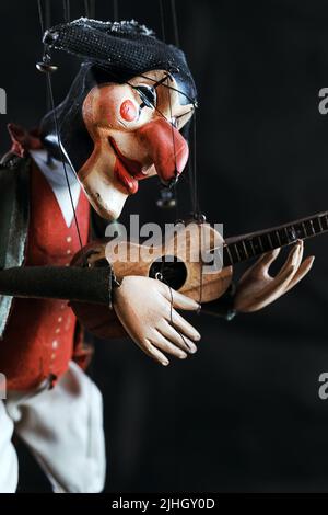 Handgefertigte Harlekin-Puppe. Puppenpuppe im Stil von del arte auf Streicher mit selektivem Fokus Stockfoto