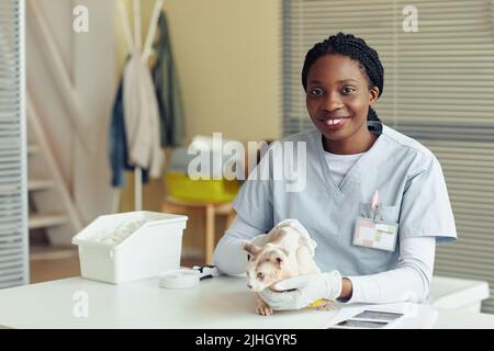 Porträt einer jungen Tierärztin, die lächelt an der Kamera, während sie mit der Katze in der Tierarztklinik posiert, Kopierraum Stockfoto