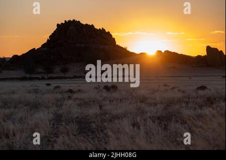 Afrikanischer Sonnenuntergang mit Bergen und Grasebenen Stockfoto