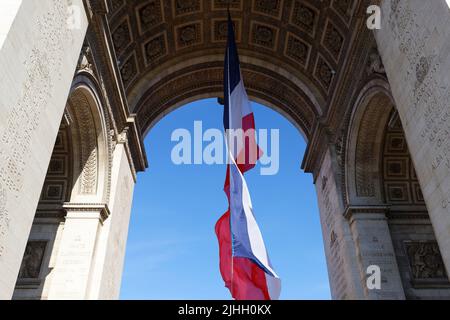 Die französische Flagge unter dem Triumphbogen. Das Grab des unbekannten Soldaten. Paris, Frankreich. Inschrift auf Bogen in Französisch: Namen von Schlachten -Eigenwort Stockfoto