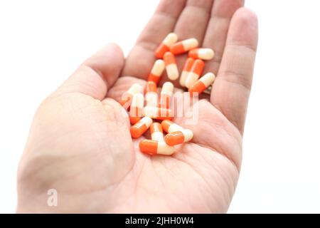 Vitamine Und Nahrungsergänzungsmittel. Nahaufnahme der Hand mit verschiedenen weißen Pillen auf der Handfläche. Nahaufnahme von Medikamenten Tabletten, Kapseln aus der Hand. Der Mensch nimmt die Pille Stockfoto