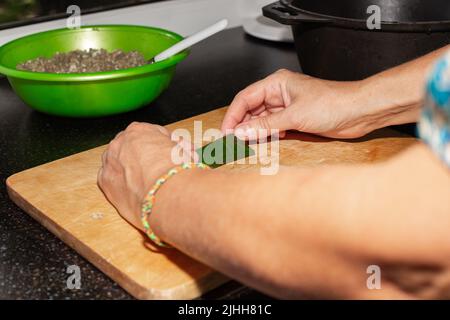 Eine Frau stopft Traubenblätter mit Fleisch. Kochen kaukasischen Gericht Dolma. Stockfoto