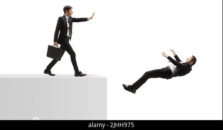 Gemeiner Geschäftsmann schiebt einen anderen Geschäftsmann auf den Rand einer Wand isoliert auf weißem Hintergrund Stockfoto