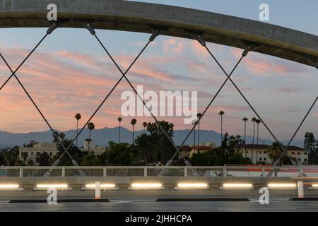 Palmen verkrachten vor einem wunderschönen Sonnenuntergang, der durch die Straßenbrücke von 6. in Los Angeles gesehen wurde Stockfoto
