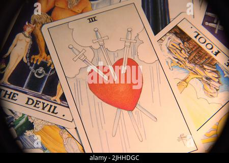 Traditionelle Tarot-Karten, die in einem unordentlichen Stapel auf einer flachen Oberfläche liegen, nah genug, um jedes Detail zu sehen. Echte Farben. Kein Filter. Stockfoto