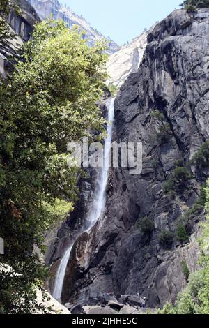 Eine atemberaubende Aussicht auf die Lower Yosemite Falls im Yosemite National Park von der Nähe der Basis bei voller Sommersonne. Stockfoto