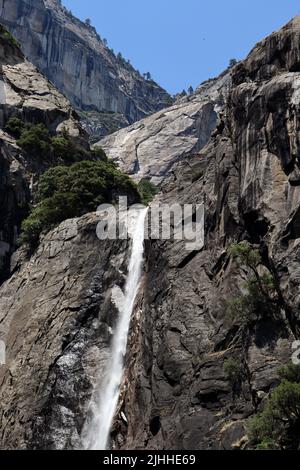 Eine atemberaubende Aussicht auf die Lower Yosemite Falls im Yosemite National Park von der Nähe der Basis bei voller Sommersonne. Stockfoto