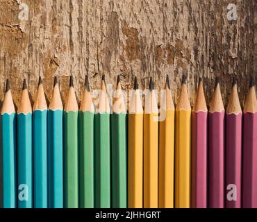 Buntstifte auf Holzhintergrund. Draufsicht mit Kopierbereich. Flach liegend. Zurück zur Schule, Bildungskonzept. Stockfoto