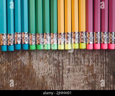 Buntstifte mit Radiergummi auf Holzhintergrund. Draufsicht mit Kopierbereich. Flach liegend. Zurück zur Schule, Bildungskonzept. Stockfoto