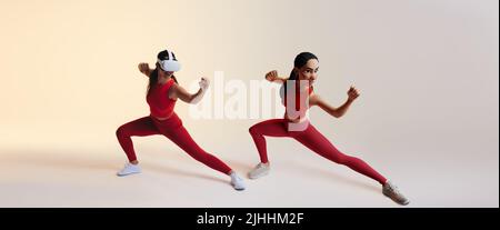 Glückliche junge Frau spielt ein Kampfspiel im Metaverse. Junge Frau spielt Videospiele der virtuellen Realität als Avatar aus dem Jahr 3D. Fröhliche junge Frau genießen Stockfoto