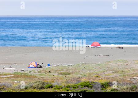 Zwei farbenfrohe Zelte am Strand entlang des PCH Stockfoto