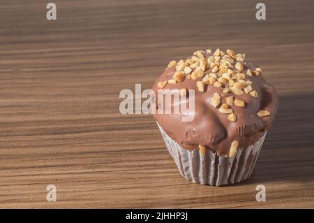 Schokoladen-Cupcake, Schokoladenmuffin mit Kastanien, auf einem Holztisch mit Platz zum Kopieren. Stockfoto