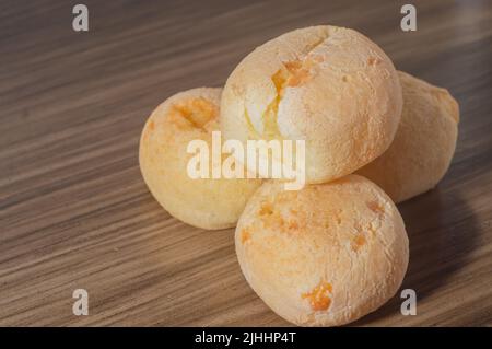 Käsebuns auf einem Holztisch mit Kopierraum, traditionelles brasilianisches Käsebrot, sehr berühmt im Bundesstaat Minas Gerais. Stockfoto