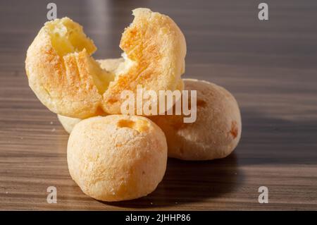 Käsebuns auf einem Holztisch mit Kopierraum, traditionelles brasilianisches Käsebrot, sehr berühmt im Bundesstaat Minas Gerais. Stockfoto