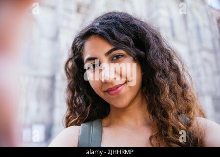 Selbstportrait mit Telefon einer attraktiven indischen jungen Frau, die in den Straßen die Kamera anschaut Stockfoto