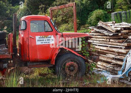 Ein alter, zerstörter Lastwagen mit dem Logo „Stewart Island Storage and Spedition, Half Moon Bay“, fotografiert auf Stewart Island, Neuseeland Stockfoto