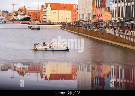 Danzig Polen Mai 2022 touristische Schifffahrt Altstadt in Danzig. Das Schiff mit Touristen fährt auf der Granary Island Reflection in Moltawa River Cityscap zu einer Kreuzfahrt am Flussufer ab. Uralter Kran. Besuchen Sie Danzig Poland Travel Destination. Touristenattraktion Stockfoto