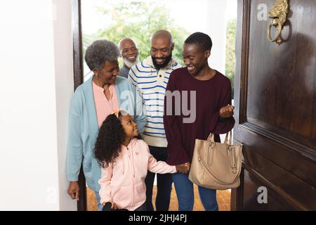 Bild einer glücklichen, mehrgenerationenigen afroamerikanischen Familie, die das Haus betreten hat Stockfoto
