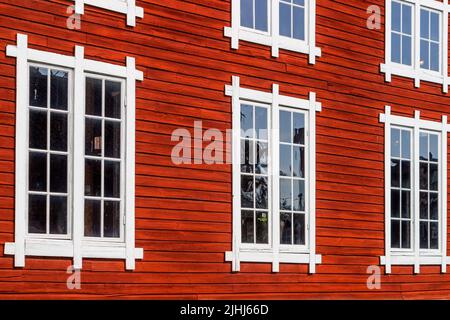 Wunderschöne alte rote Holzfassade mit Fenstern Stockfoto