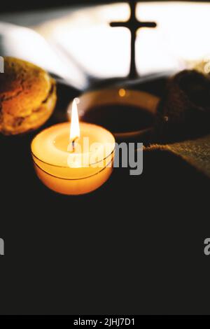 Heilige Kommunion symbolisiert das heilige Blut und Fleisch Jesu Christi Letztes Abendmahl Wein und Brot, das Kreuz des Leidens, Kerzen und die Bibel Stockfoto